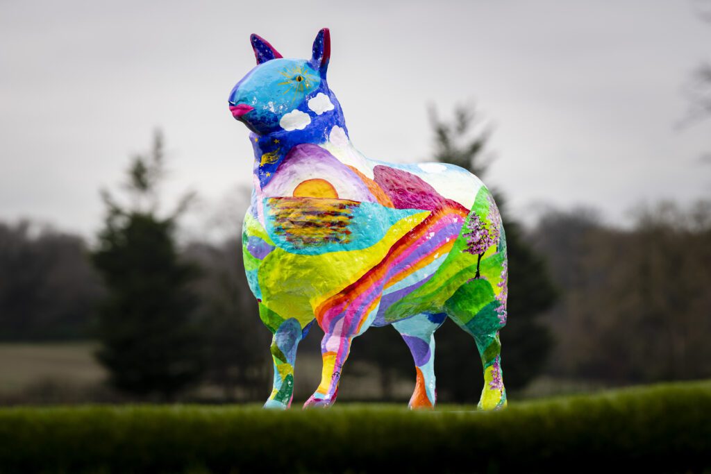 A statue of a colourful sheep.