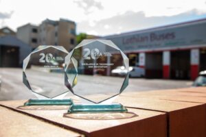 The two glass awards sitting on a wall in the sunshine in front of the bus garage.