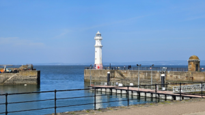Newhaven Harbour with a blue sky in the background. The lighthouse stands out in the centre of the photo.