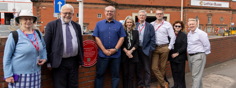 A group of people standing next to the Red Wheel outside Lothian's Annandale Street depot.