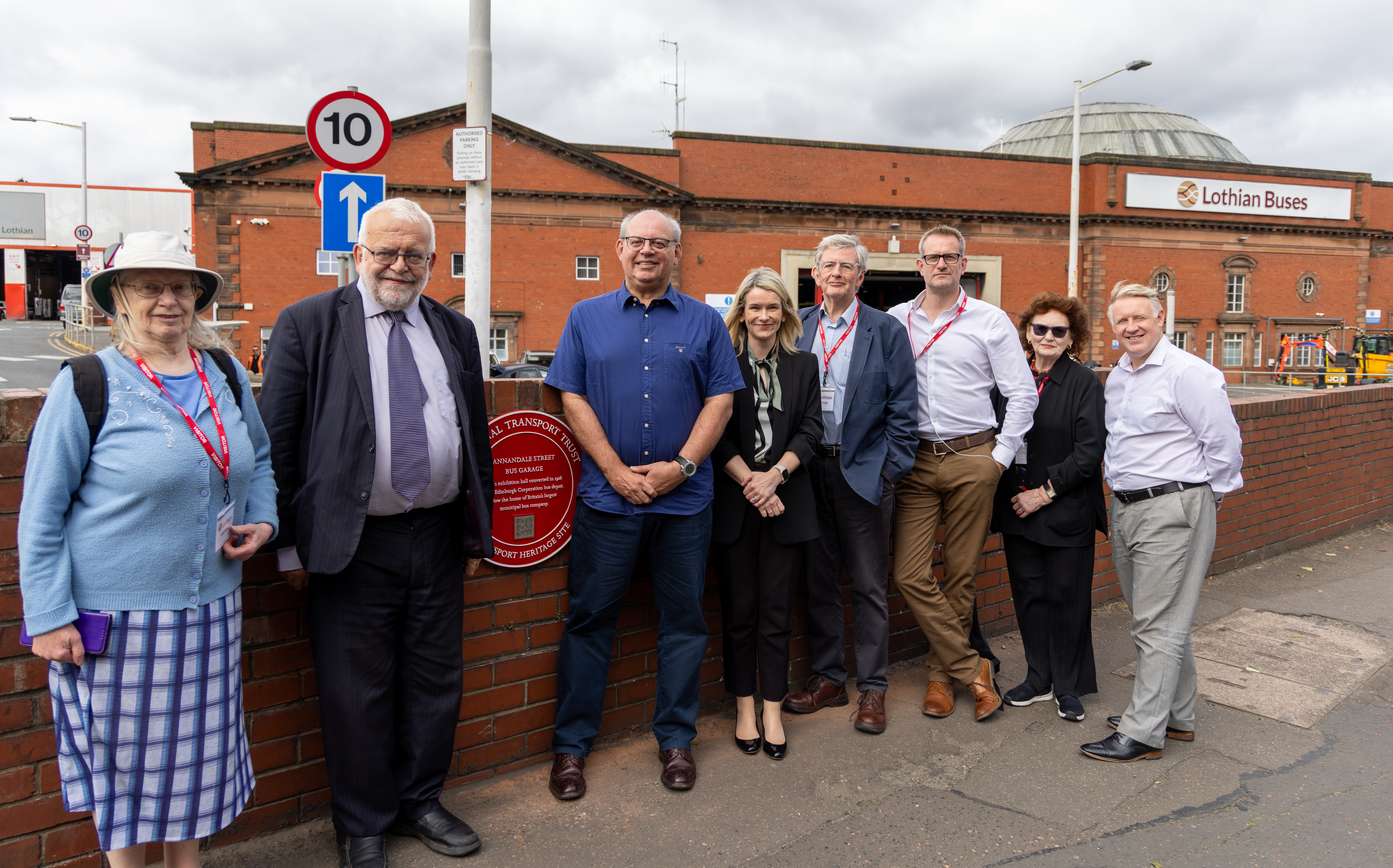 A group of people standing next to the Red Wheel outside Lothian's Annandale Street depot.