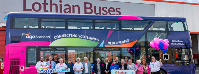 Representatives from Age Scotland and Lothian Buses standing in front of the new charity bus at the garage in Annandale Street.