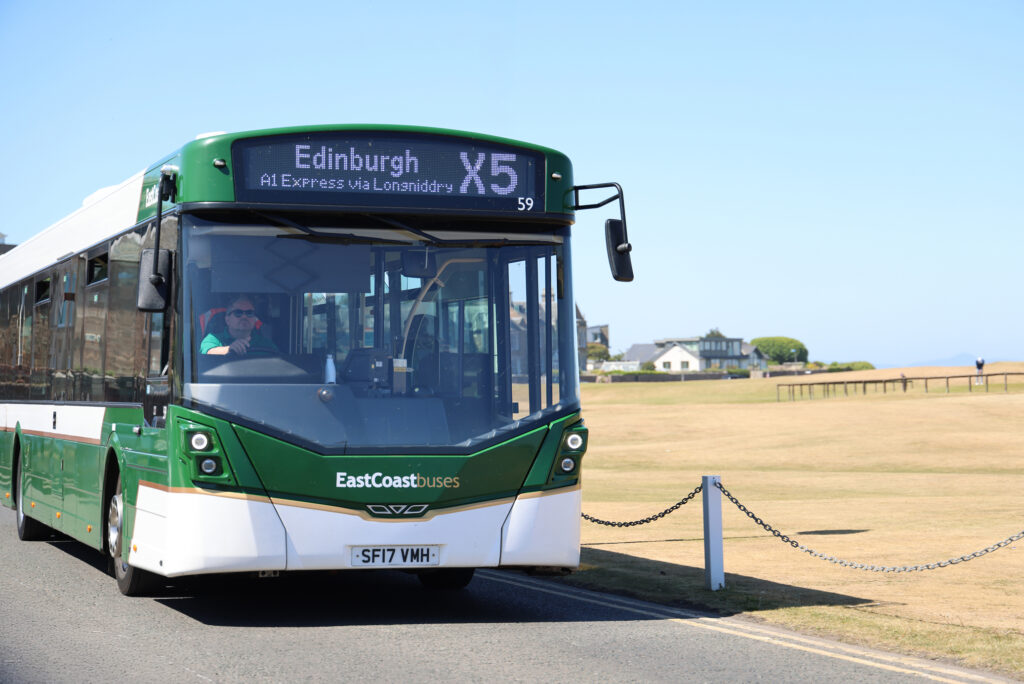 East Coast Bus driving alongside a golf course in East Lothian