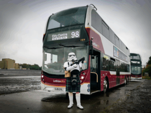 A stormtrooper stands in front of a Service 98 bus.